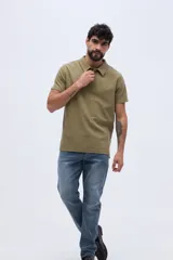 Remera polo verde militar con textura sutil, de manga corta, cuello camisero y cierre frontal de botones.