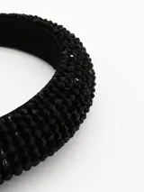 Vincha acolchada de color negro, completamente cubierta con pequeñas cuentas facetadas brillantes.