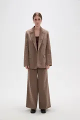 Blazer de corte holgado con diseño de rayas verticales, cuello solapa y cierre frontal con un botón. Cuenta con bolsillos laterales con solapa.