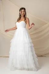 Vestido largo blanco de tul, estilo strapless con corsé drapeado en forma de corazón y falda amplia con múltiples volados.