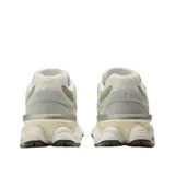 Championes New Balance modelo 9060, con diseño robusto y moderno. Presentan una combinación de tonos beige y gris, con paneles de gamuza y malla. Incluyen el logo 'N' característico en los laterales y una suela gruesa con tecnología de amortiguación.