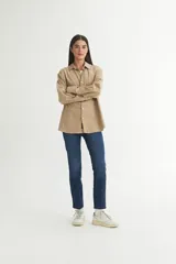 Camisa beige de algodón con cuello solapa clásico, bolsillo cuadrado en el pecho, botones personalizados y calce oversize.