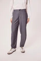 Pantalón gris a rayas verticales blancas, de corte recto y tiro medio.