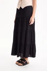 Pollera larga de viscosa color negro, con diseño escalonado de volados y cintura elástica.