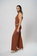 Mono largo color marrón con textura, escote halter, corte holgado, cinturón de cuero con estampado animal y cierre frontal con botones.