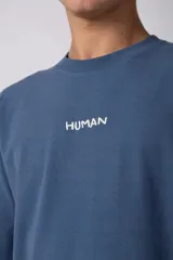 Remera de corte oversize color negro, con cuello redondo y estampa minimalista con la palabra 'HUMAN' en el pecho.