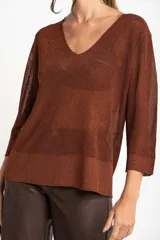 Sweater de punto con acabado brillante, cuello en V y mangas tres cuartos. Presenta un diseño holgado y tejido traslúcido.