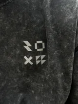 Remera gris con efecto gastado, corte oversize, mangas cortas y estampado en la espalda con el texto "SUPPLY GOODS DESIGNED IN PUNTA DEL ESTE".