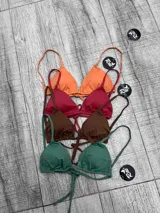 Corpiño de bikini tipo triángulo con copas removibles. Se ata en la espalda y tiene tiras ajustables que también permiten atarlo al cuello.