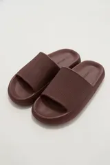 Chancletas de goma color marrón, con diseño texturizado en la tira superior y suela gruesa con plantilla anatómica antideslizante.