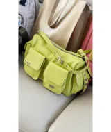 Bandolera color verde lima de tamaño grande, con dos bolsillos frontales y dos bolsillos laterales con broche imán. Tiene correa regulable y extraíble, interior forrado y bolsillo interno con cierre.