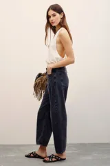 Jean de corte barrel color negro gastado, tiro medio y diseño amplio en las piernas con efecto relajado.