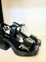 Sandalias de cuero charol negro con plataforma delantera y taco cuadrado.