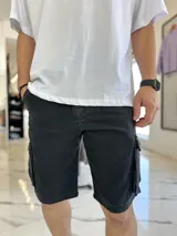 Bermuda de jean cargo color negro, con bolsillos laterales y corte oversize.