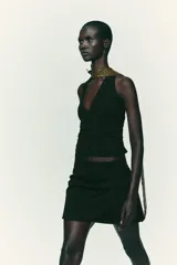 Falda pantalón negra de tiro alto con diseño cruzado y pliegues drapeados en el frente.