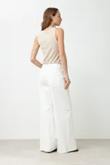 Pantalón de jean blanco, tiro alto, de corte ancho (wide leg) y largo.
