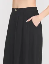 Pantalón palazzo de lino y viscosa, color blanco, de tiro alto y silueta amplia. Presenta pinzas frontales, bolsillos laterales y cierre con botón.