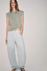 Pantalón cargo de tiro medio, confeccionado en mezcla de algodón y lino, con perneras anchas, bolsillos de plastrón en el delantero y cierre frontal con cremallera y botón.