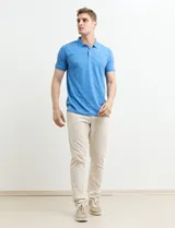 Remera polo azul marino de manga corta, con cuello y tapeta de dos botones. Presenta aberturas laterales en el dobladillo.