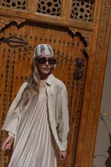 Camisa de lino negra con bordados dorados en forma de árbol o palmera estilizada. Presenta cuello camisero, botones frontales dorados y pliegues verticales en la parte inferior delantera.