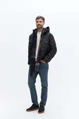 Campera de nylon matelaseada con capucha integrada, cierre frontal y diseño de costuras geométricas. Presenta un ajuste regular y es ideal para climas fríos.