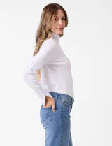 Polera de tejido fino con cuello alto, manga larga y detalle de tajo en los puños.