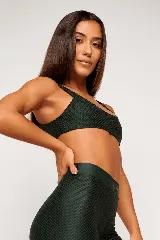 Top deportivo color verde oscuro, con tirantes finos y espalda descubierta. Diseño reversible con un lado brillante y otro con textura 3D tipo colmena.