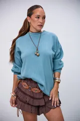 Sweater de punto color menta, con cuello redondo, mangas largas y aberturas laterales en el dobladillo.