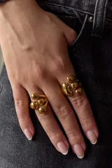 Anillo ajustable de acero quirúrgico dorado con diseño orgánico e irregular de formas redondeadas estilo gota.