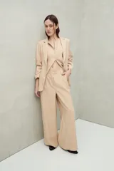 Pantalón de vestir color beige con finas rayas verticales, corte wide leg y doble botón en la pretina.