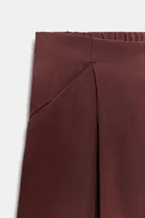 Pantalón tipo culotte de tiro medio, con pierna ancha, bolsillos delanteros y detalle de pinzas. Cuenta con cierre frontal de cremallera y gancho metálico.