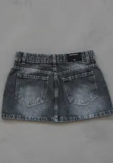 Minifalda de jean rígido color negro con efecto lavado acid wash, tiro bajo y diseño de bolsillos delanteros superpuestos con detalles de tachas metálicas.