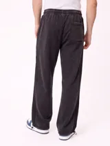 Pantalón jogger holgado de color gris con efecto acid wash y franjas laterales negras. Cuenta con cintura elástica con cordón ajustable y bolsillos laterales.