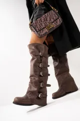 Botas altas de cuero color marrón con múltiples correas con hebillas plateadas.