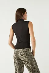 Top sin mangas de cuello alto, confeccionado en tejido liviano y suave con ajuste al cuerpo.