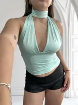 Top amarillo pálido con cuello halter y escote profundo. Se puede usar de múltiples formas.