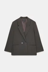 Blazer oversize de corte recto con estampado de raya diplomática. Presenta cuello con solapa, cierre frontal cruzado con botones, hombros caídos y bolsillos delanteros con vivo.