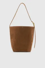 Cartera tipo shoulder bag confeccionada en gamuza color marrón, con diseño minimalista, silueta amplia, correa ajustable con hebilla metálica dorada y herrajes a tono.