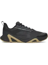 Championes de entrenamiento Under Armour modelo Charged Commit TR 5, color negro con detalles en beige en la suela. Presentan parte superior de malla transpirable con revestimientos de cuero, entresuela Charged Cushioning para absorción de impactos y suela de goma con refuerzos laterales.