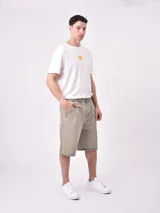 Bermuda de denim en tono verdoso claro, con bolsillos laterales y traseros, de corte holgado y diseño casual.