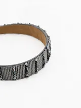 Vincha rígida forrada con tejido de cuentas metálicas plateadas y cristales facetados en tonos grises, con interior de gamuza suave.