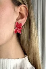 Aros con diseño de flor en tono rojo y bordes dorados, ideales para realzar cualquier look.