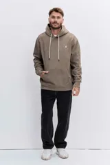 Buzo tipo canguro con capucha, confeccionado en tela de corderoy color marrón. Presenta cordones blancos ajustables en la capucha, bolsillo frontal tipo canguro y un pequeño bordado en el pecho.