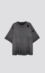 Remera de manga corta, calce extra oversize, color gris oscuro con efecto gastado/degradado. Presenta roturas y detalles deshilachados en cuello, hombros y puños.