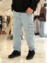 Pantalón cargo de jean azul con múltiples bolsillos en los laterales y diseño holgado.
