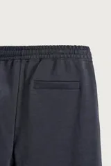 Bermuda estilo jogger de ajuste relajado, confeccionada en tejido interlock de algodón. Cuenta con cintura elástica ajustable con cordón, bolsillos frontales de vivo y diseño liso.