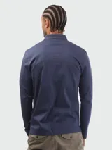 Remera polo de manga larga Boss en color azul marino, confeccionada en algodón interlock. Presenta cierre frontal de dos botones, cuello camisero clásico y sutil logotipo bordado en el pecho.