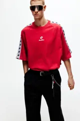 Remera de algodón oversized color rojo, con cuello redondo y mangas cortas raglán decoradas con una franja blanca lateral con logotipos negros de Lotto. Cuenta además con el logo de la marca estampado en el centro del pecho.