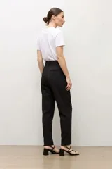 Pantalón sastrero color topo, de corte recto, con pinzas en la parte delantera y cinturón del mismo género con hebilla cuadrada.
