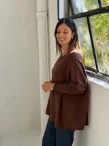Sweater de punto color chocolate, con cuello redondo, mangas largas con puños ajustados y diseño holgado de corte amplio.